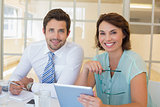 Smiling business people with digital tablet in office