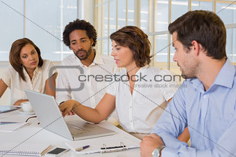 Business people using laptop in meeting at office