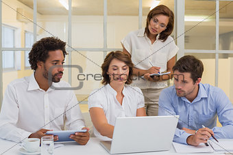 Business people using laptop in meeting at office