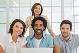 Portrait of smiling business people using laptop