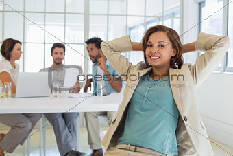 Relaxed businesswoman with colleagues in meeting at office