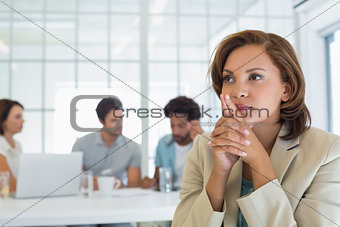 Close-up of serious businesswoman with colleagues in meeting