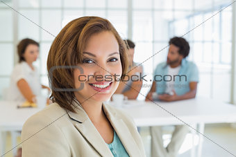 Close-up of smiling businesswoman with colleagues in meeting