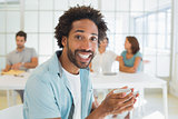 Cheerful businessman having coffee with colleagues at office