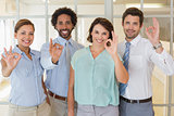 Business colleagues gesturing okay sign in office