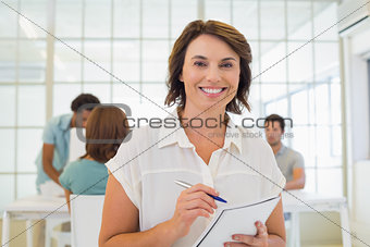 Businesswoman writing notes up with colleagues in meeting
