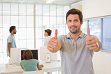 Businessman gesturing thumbs up with colleagues in meeting