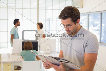 Businessman reading newspaper with colleagues in meeting