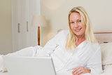Relaxed woman with laptop in bed