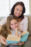 Woman and daughter reading story book