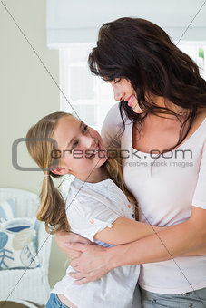Daughter embracing mother in house