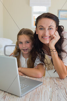 Girl and mother with laptop at table
