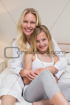 Mother and daughter sitting in bed