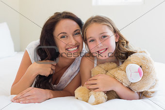 Woman with daughter lying in bed