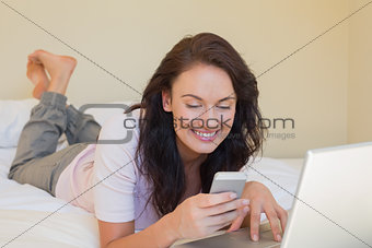 Woman text messaging while lying in bed