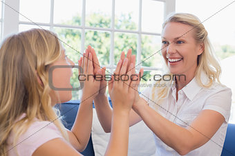 Mother playing clapping game with daughter