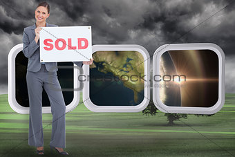 Composite image of happy real estate agent with sold sign