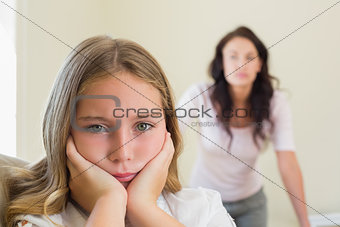 Sad girl with mother in background