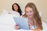 Girl using digital tablet in bed
