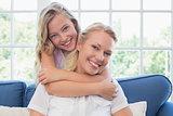 Girl embracing mother from behind in living room