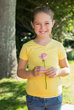 Girl holding flower in park