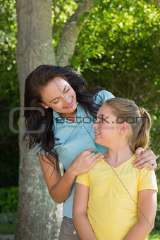 Mother and daughter looking at each other in park