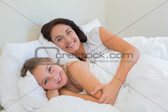 Mother and daughter lying in bed