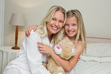 Mother and daughter hugging in bed