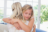 Girl with eyes closed hugging mother