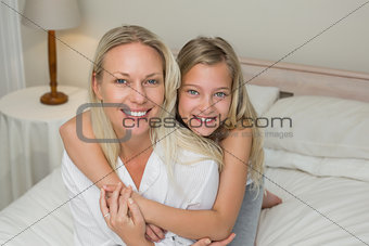 Mother and daughter sitting together in bed