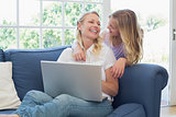 Mother and daughter with laptop looking at each other