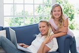 Happy woman and daughter with laptop