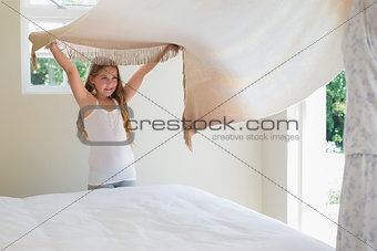 Girl making bed with mother