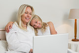 Relaxed mother and daughter surfing on laptop