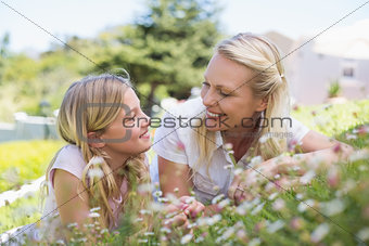Mother and daughter lying in park