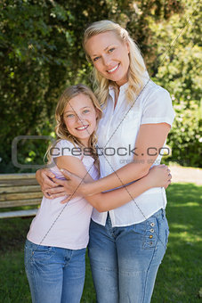 Mother and daughter embracing in park