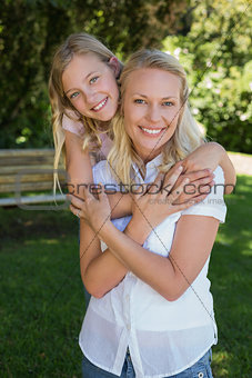 Girl embracing mother from behind in park