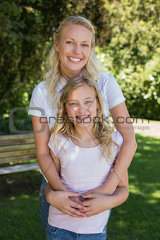 Happy woman embracing girl in park