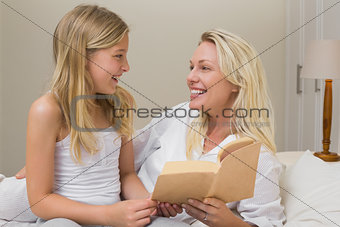 Mother and daughter with novel in bed