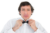 Handsome groom corrects bow tie