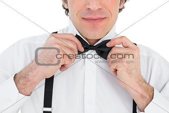 Man adjusting bow tie
