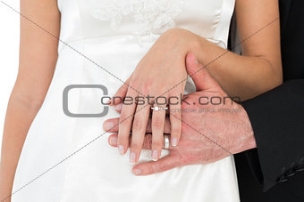 Mid section of bride and groom wearing wedding ring