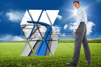 Composite image of serious businessman standing with hand in pocket