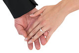 Close-up of bride and groom with hands together