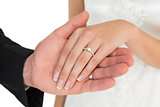 Cropped image of newly wed couple holding hands
