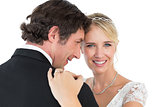 Bride embracing groom over white background