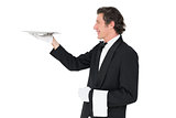 Waiter carrying tray against white background