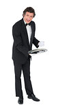 Confident waiter showing empty tray over white background
