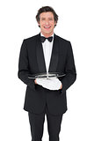 Happy waiter holding empty tray over white background