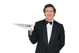 Confident waiter holding serving tray